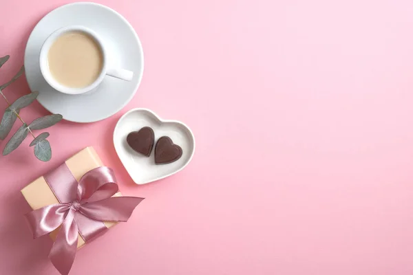 Ρομαντική σύνθεση Ημέρα του Αγίου Βαλεντίνου με φλιτζάνι καφέ, κουτί δώρου, γλυκό καραμέλα σε σχήμα καρδιάς σε ροζ φόντο. Επίπεδο lay, πάνω όψη, αντιγραφή χώρου. — Φωτογραφία Αρχείου