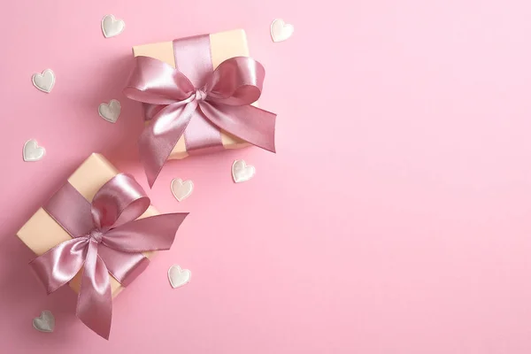 Twee geschenken en valentijnskaartjes op roze achtergrond. Vlakke lay, bovenaanzicht. Begrip Valentijnsdag, jubileum, moederdag en verjaardagsgroet — Stockfoto