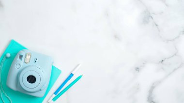 Düz konum modern hazır kamera, nane kağıdı defter, mermer masa üzerinde fotokopi alanı olan kırtasiye malzemesi. Kız ofis masası, kadınsı çalışma alanı konsepti.