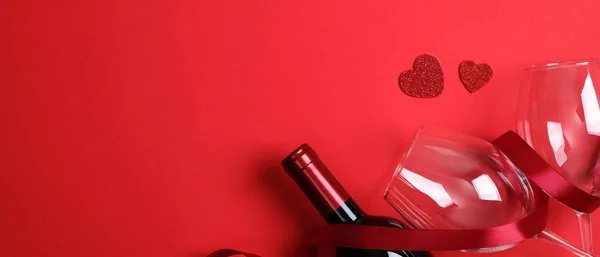 Valentijnsdag banner sjabloon. Top view fles wijn champagne, twee glazen en lint op rode achtergrond. Valentijnsdag feest, liefde, romantisch diner koppel concept — Stockfoto