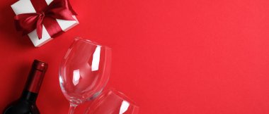 Sevgililer Günü yemeği konsepti. Romantik akşam yemeği, bir şişe şarap şampanyası, bardaklar, beyaz hediye kutusu. Sevgililer Günü kartı. Sevgililer Günü afişi kopyalama alanı ile modelleme.