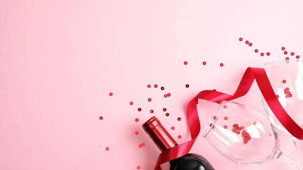 Joyeux modèle de bannière Saint-Valentin. Table avec bouteille de vin et verres sur fond rose avec ruban rouge et confettis. Carte de voeux, flyer, maquette d'affiche pour la Saint Valentin — Photo