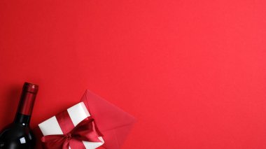 Sevgililer Günü arkaplanında şarap şişesi, sevgililer günü hediye kutusu kırmızı masa manzaralı aşk mektubu olan bir zarf. Kopya alanı ile en az düz konum biçimi. Romantik yemek çifti konsepti