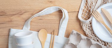 Üst düzey çevre dostu aletler, bambu çatal bıçak takımı, pamuk ve ip torbaları, tahta masanın üzerinde kutu yumurta. Sürdürülebilir yaşam tarzı. Sıfır atık, plastiksiz konsept