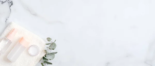 Natuurlijke cosmetische lotion flessen, handcrème en eucalyptus blad op marmeren achtergrond. Platte lay, bovenaanzicht, kopieerruimte. Handhuidverzorging, concept biologische schoonheidsproducten — Stockfoto