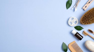 Mavi arka planda hiç atık banyo aksesuarı yok. Düz bambu diş fırçaları, ahşap saç fırçası, el yapımı sabun, masaj fırçası, luffa süngeri ve yeşil yapraklar. Doğal organik Spa kozmetik ürünleri