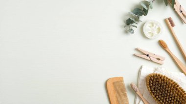 Yeşil masada sıfır atık banyo aksesuarı. Üst manzara banyo fırçası, ahşap saç tarağı, bambu diş fırçası, luffa süngeri, havlu. Çevre dostu banyo ürünleri, güzellik ve kaplıca tedavisi konsepti