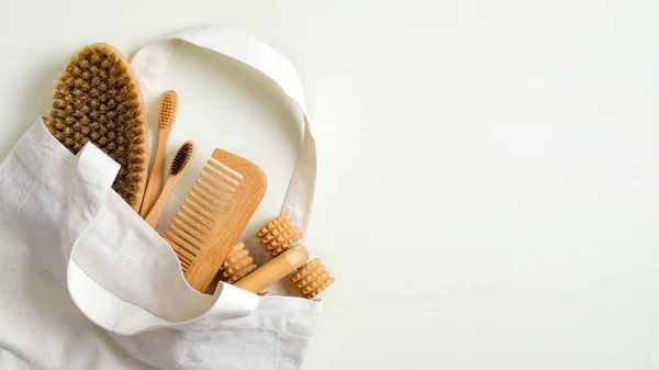 Zero waste bathroom accessories in cotton bag. Bath peeling brush, wooden hair comb, massage tool, bamboo toothbrushes. Eco-friendly bath products, beauty and SPA treatment concept — 스톡 사진
