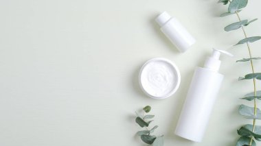 Organik kozmetik ürünler ve okaliptüs yaprakları çerçevesi. Üst görünüm el kremi, gerekli yağ ve losyon. Doğal kozmetik, el bakımı konsepti. Güzellik salonu için pankart modeli