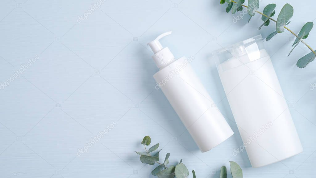 Natural organic cosmetic products concept. SPA cosmetic packaging branding mockup. Minimalist flat lay set with plastic pump bottle for liquid soap, eucalyptus green leaves, shampoo bottle container