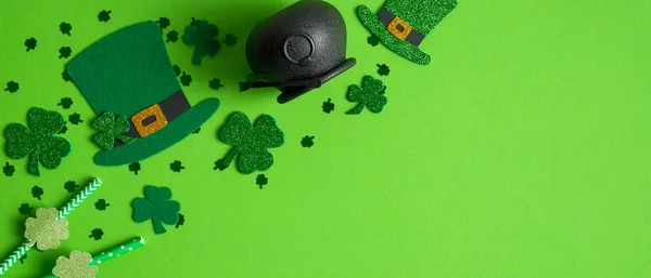 Happy Saint Patrick 's day banner mockup. Shamrock e quatro trevos de folhas, chapéus de elfo irlandeses, pote de ouro e palha de bebida em fundo verde. Conceito de dia St. Patricks . — Fotografia de Stock