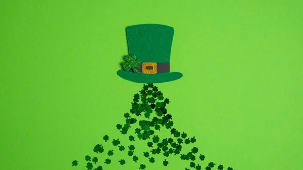 Glad St. Patricks Day koncept. Kreativ layout med irländsk alvhatt med shamrock blad klöver och konfetti på grön bakgrund. Platt ligg, ovanifrån — Stockfoto