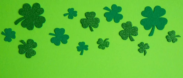 Ram gränsen mellan shamrock och fyra blad klöver på grön bakgrund. Glad St. Patricks Day koncept. — Stockfoto
