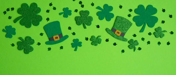 框架边的洗发水，四个叶三叶草和爱尔兰精灵帽绿色背景。 圣帕特里克快乐日的概念. — 图库照片