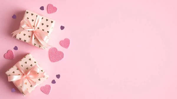 Plantilla de tarjeta de San Valentín. Cajas de regalo y corazones sobre fondo rosa. Concepto de celebración del Día de San Valentín. Diseño creativo para tarjeta de felicitación, invitación a la fiesta, banner, volante —  Fotos de Stock