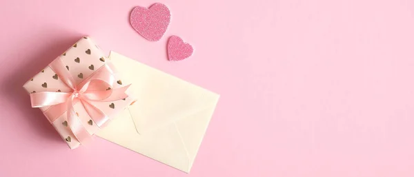 Cutie cadou Ziua Îndrăgostiților și scrisoare pe fundal roz cu inimi. Șablon banner de Ziua Îndrăgostiților, mockup felicitări. Plat lay, vedere de sus — Fotografie, imagine de stoc