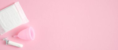 Regl hijyen ürünleri. Üst düzey hijyenik ped, yeniden kullanılabilir silikon bardak, pembe arka planda fotokopi alanı olan tampon. Kritik günler, adet döngüsü, kadın sağlık konsepti