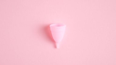 Reusable menstrual cup isolated on pink background. Alternative menstrual hygiene product. Critical days, menstruation cycle, female healthcare concept clipart