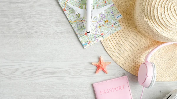 Concepto de viaje o vacaciones de verano en mesa de madera. Modelo de avión de vista superior, mapa, sombrero de playa, auriculares rosa y documento de pasaporte. Plantilla de diseño de banner de agencia de viajes —  Fotos de Stock