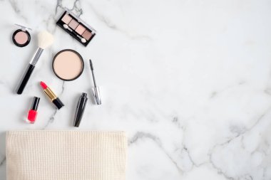 İçinde kozmetik ürünler olan makyaj çantası mermer arka plana dökülüyor. Düz yatıyordu, yukarıdan görünüyordu. Güzellik günlüğü pankartı tasarım şablonu