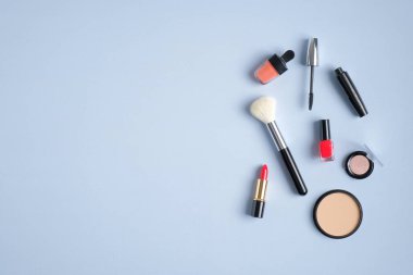 Makyaj ürünleri ve araçları mavi arka planda. Kopyalama alanı olan üst görünüm. Güzellik salonu afişi tasarım şablonu