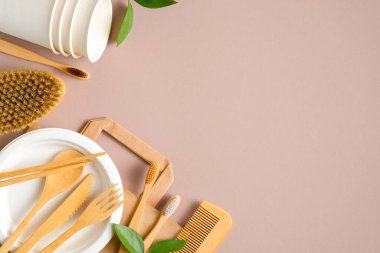 Kahverengi arka planda çevre dostu çatal bıçak seti ve banyo aksesuarları. Düz yerde, üst tarafta. Plastiksiz, sıfır atık konsepti. Sürdürülebilir yaşam tarzı.