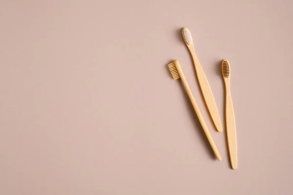 茶色の背景に竹の木の歯ブラシ 環境に優しい プラスチックフリー 無駄のない歯科用ツールのコンセプト フラットレイアウト トップビュー — ストック写真