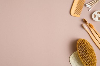 Kahverengi arka planda çevre dostu banyo aksesuarları. Düz kulak çubukları, bambu diş fırçaları, saç fırçası, banyo fırçası, luffa süngeri. Güzellik ve Kaplıca Tedavi Konsepti