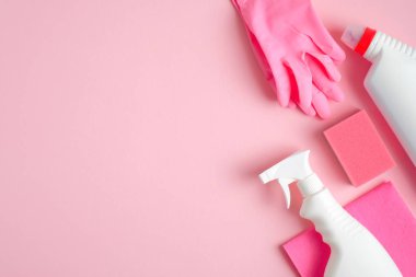 Pembe arka planda temizlik malzemeleri. Ev temizliği ve oda servisi konsepti. Üst görünüm sprey şişesi, sünger, lastik eldiven ve temizlik deterjanı..