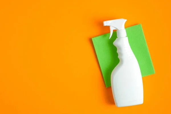 Leere Reinigungssprühflasche Und Grüner Lappen Auf Orangefarbenem Hintergrund Flache Lage — Stockfoto