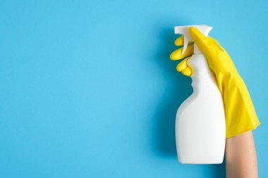 Sarı lastik eldiven, temiz sprey şişeyi mavi arka planda tutar. Temizlik servisi afişi. Temizlik ve temizlik konsepti. Düz yatış, üst görünüm