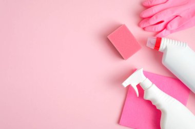 Pembe arka planda temizlik malzemeleri. Üst manzara sprey şişesi, bez, sünger, deterjan, lastik eldiven. Ev temizliği ve temizlik konsepti