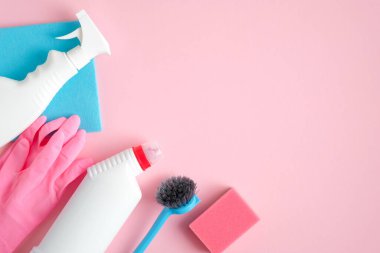 Pembe arkaplanda kopyalama alanı olan temizlik araçları. Ev temizliği ve oda servisi konsepti. Düz yatış, üst görünüm.