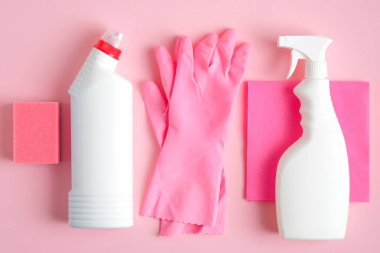 Pembe arka planda temizlik malzemeleri. Ev temizliği ve oda servisi konsepti. Düz yatış, üst görünüm.