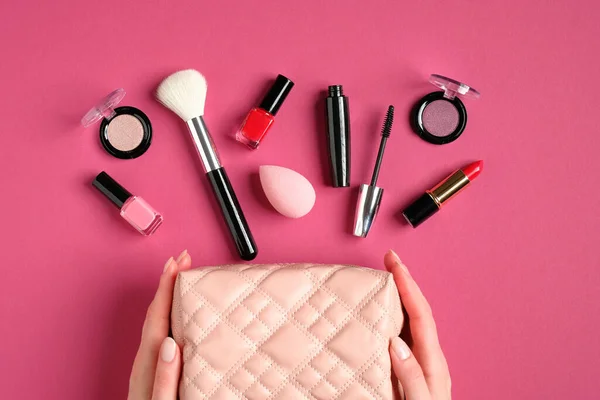 Weibliche Hände Halten Eine Schminktüte Mit Kosmetikprodukten Auf Rosa Hintergrund — Stockfoto