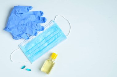 El antibakteriyel antiseptik jel, yüz maskesi, mavi arka planda lastik eldivenler. Coronavirus Hastalığı (Covid-19) grip virüsü salgını sırasında önleme ve sağlık koruma.