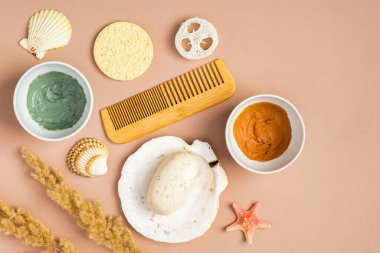 Şeftali rengi arka planda kozmetik kil maskeler ve aksesuarlar. SPA doğal organik güzellik ürünleri, yaz yüz bakımı konsepti. Üst manzara, düz uzanma