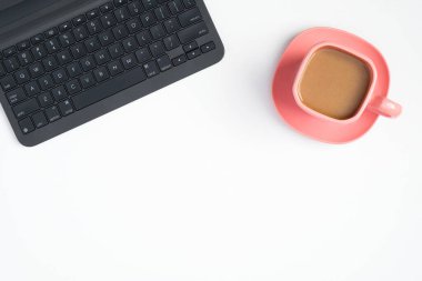 Dizüstü bilgisayar klavyesi ve beyaz arka planda pembe kahve fincanı. Zarif kadın çalışma alanı konsepti Üst görünüm, düz yatış