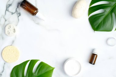Mermer zemin üzerinde doğal SPA kozmetik çerçevesi. Cilt bakımı için organik güzellik ürünleri, tropikal yapraklı vücut ve saç bakımı. Güzellik tedavisi konsepti. Düz konum, üst görünüm, kopyalama alanı