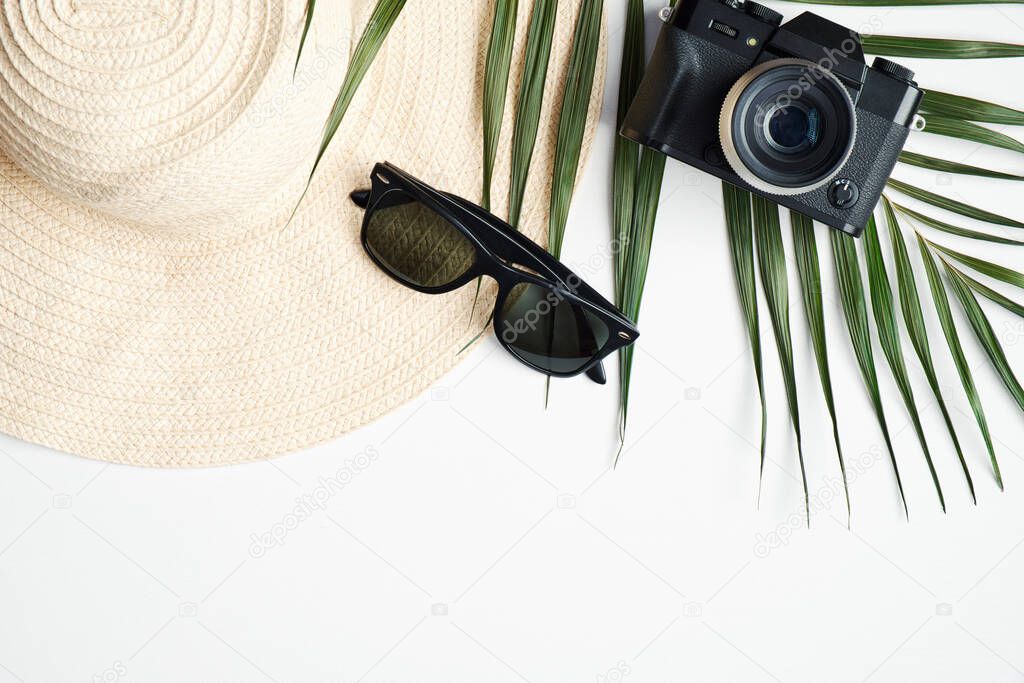 Traveler accessories with tropical palm leaf branches on white background. Travel vacation concept. Flat lay, top view, copy space
