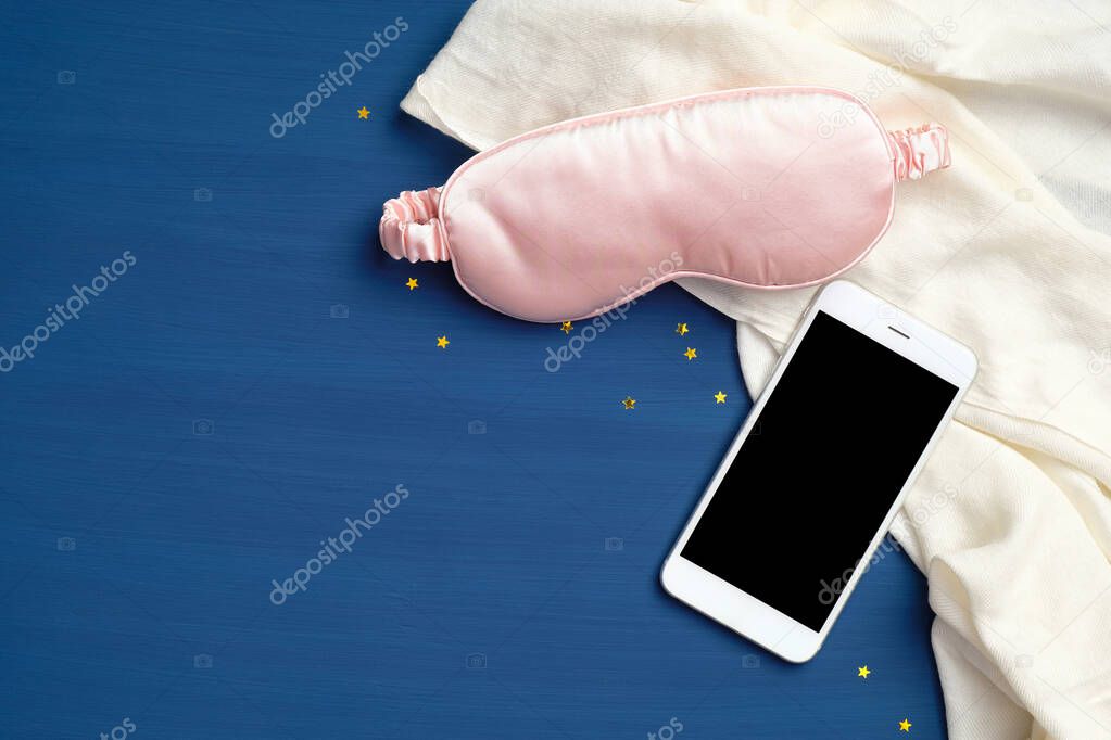Sleeping eye mask, smartphone with blank screen mockup, blanket on classic blue background. Healthy sleep, sleep tracker, diagnostic app with analysis concept. Flat lay, top view