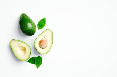 Beyaz arka planda yeşil yapraklı avokado. Düz konum, üst görünüm, kopyalama alanı.
