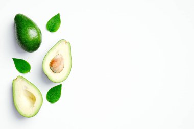 Beyaz arka planda yeşil yapraklı taze olgun avokado. Düz konum, üst görünüm, kopyalama alanı.
