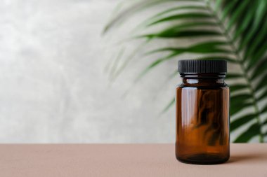 Tropikal yapraklı boş ilaç şişesi. Şeffaf ilaç şişesi, kahverengi cam maketi..