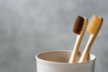 Camda çevre dostu bambu diş fırçaları, yakın çekim manzarası. İki ayrıştırılabilir ahşap ağız hijyen aksesuarı. Sıfır atık, plastiksiz, sürdürülebilir yaşam tarzı konsepti