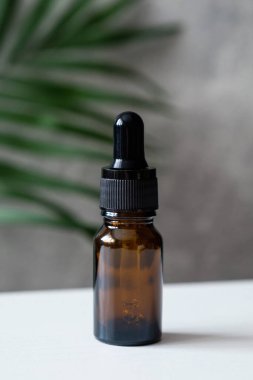Boş kehribar bardakta damlatıcıyla gerekli yağ şişesi. Doğal organik kozmetik ürünleri. Alternatif tıp, bitkisel özü, sürdürülebilir yaşam tarzı kavramı.