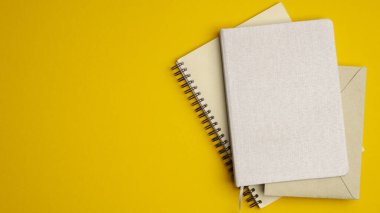 Sarı arka planda bir yığın kağıt defter. Daire, ofis malzemelerinin en iyi manzaralı okulu..