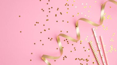 Pembe arka planda altın parti dekoru. Konfeti yıldızları, tatil süslemeleri ve parti süslemeleriyle bezenmiş düz bir kompozisyon. Noel, doğum günü ya da düğün konsepti. Düz yatış, üst görünüm.
