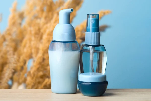 Transparent blue blank cosmetic packaging mockup. Cosmetic set of cream jar, soap pump bottles and spray lotion. Beauty products package design, skincare concept