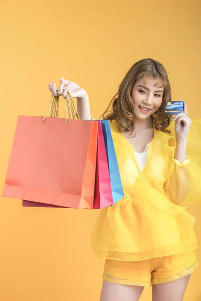 Piękna Azjatka z torbą na zakupy i kartą kredytową w ręku — Zdjęcie stockowe